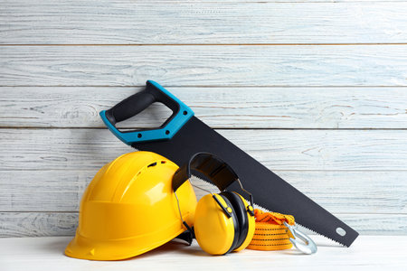 Composition with construction tools on table against wooden background, space for text