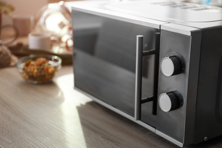 Modern microwave oven on table in kitchenの写真素材