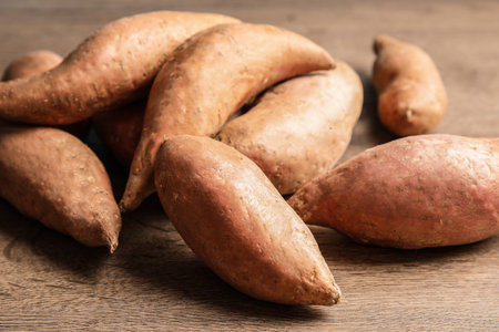 Pile of sweet potatoes on wooden backgroundの写真素材