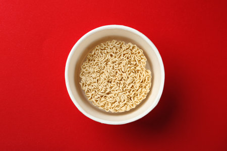 Cup of instant noodles on color background, top viewの写真素材
