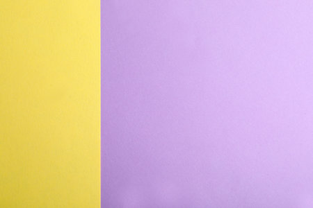 Violet and yellow paper sheets as colorful background, top viewの写真素材