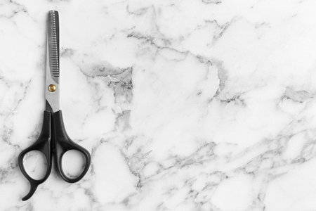 Thinning scissors and space for text on marble background, top view. hair dresser toolの写真素材