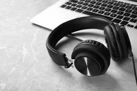 Modern headphones and laptop on table. Space for textの写真素材