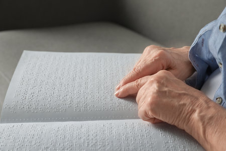 Blind senior person reading book written in Braille, closeupの写真素材