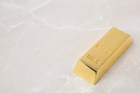 Shiny gold bar on table. Space for textの写真素材