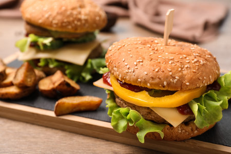 Board with delicious hamburger on table. Space for textの写真素材
