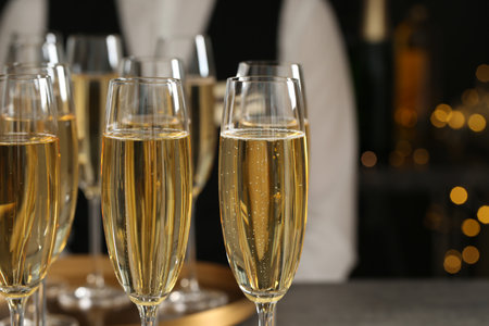 Glasses of champagne and waiter in restaurant, closeup. Space for textの写真素材