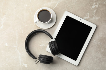 Flat lay composition with headphones, tablet and cup of coffee on table. Space for textの写真素材
