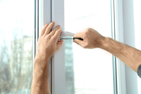 Professional construction worker installing window indoors, closeupの写真素材