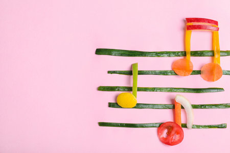 Musical notes made of fruits and vegetables on color background, top view. Space for textの写真素材
