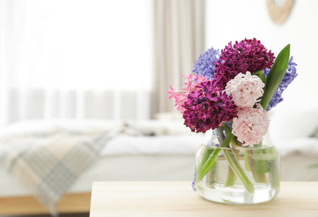 Beautiful hyacinths in glass vase on table indoors, space for text. spring flowersの写真素材