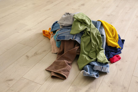 Pile of dirty laundry on wooden floor indoorsの写真素材