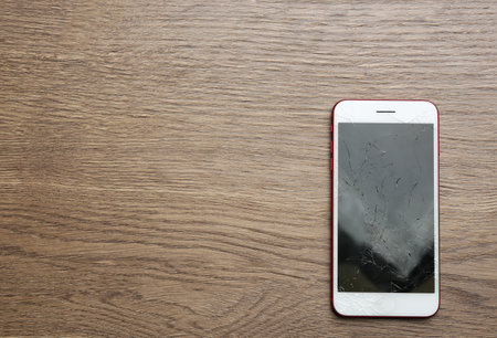 Modern smartphone with broken display and space for text on table, top view. device repairの写真素材