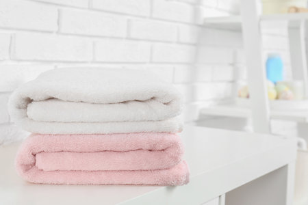Stack of fresh towels on the table in the bathroom. Space for textの写真素材