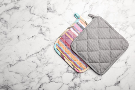 Protective oven potholders on marble table, top view with space for textの写真素材