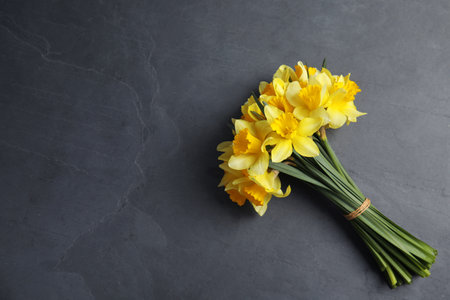 Bouquet of daffodils on dark background, top view with space for text. Fresh spring flowersの写真素材