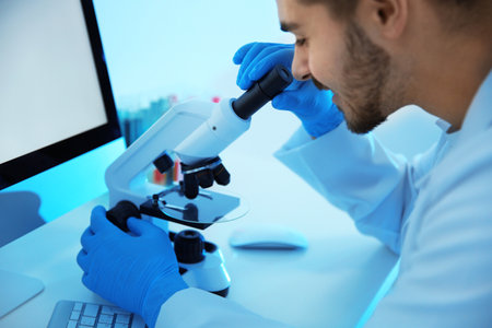 Medical student working with microscope in modern scientific laboratoryの写真素材