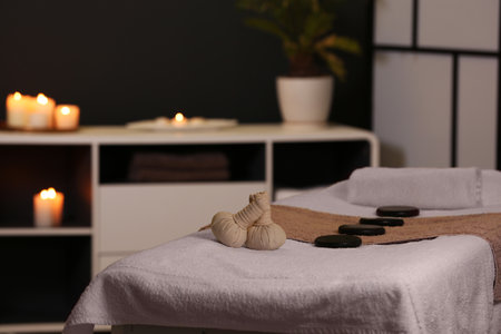 Herbal compresses and stones on massage table in spa salonの写真素材