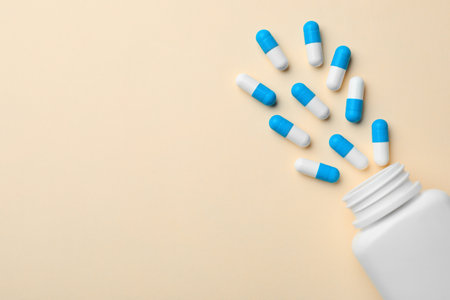 Bottle with pills on color background, flat lay. Space for text
