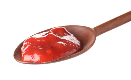 Wooden spoon with red sauce on white backgroundの写真素材