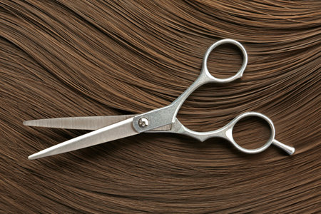 Scissors on brown hair, top view. hairdresser serviceの写真素材