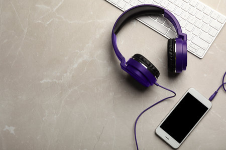 Flat lay composition with headphones, smartphone and keyboard on table. Space for textの写真素材