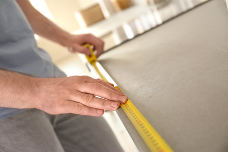 Man measuring kitchen furniture indoors, closeup. construction toolの写真素材