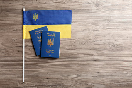 Ukrainian travel passports and national flag on wooden background, flat lay with space for text. international relationshipsの写真素材