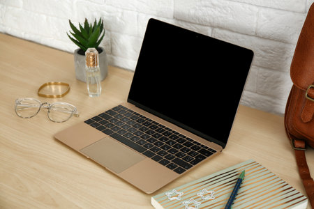 Stylish workplace with modern laptop on table near brick wall. fashion bloggerの写真素材