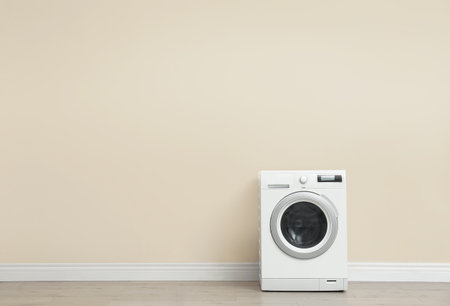 Washing machine near color wall in empty room, space for text. laundry dayの写真素材
