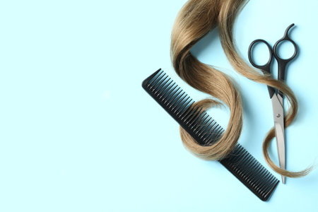 Flat lay composition with light brown hair, comb, scissors and space for text on color background. hairdresser serviceの写真素材