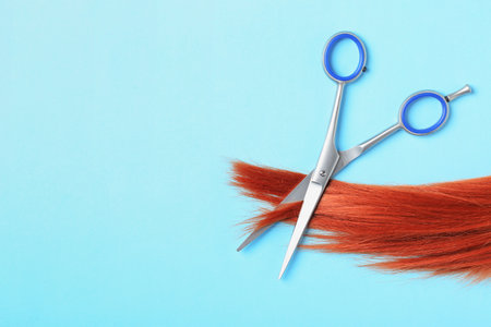 Flat lay composition with red hair, scissors and space for text on color background. hairdresser serviceの写真素材