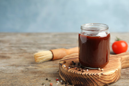 Composition with jar of barbecue sauce on wooden table. Space for textの写真素材