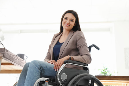 Portrait of a young woman in a wheelchair at the workplace