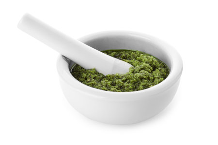 Mortar of tasty pesto sauce and pestle isolated on whiteの写真素材