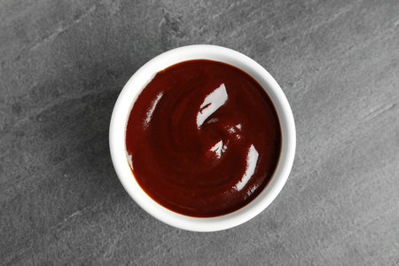 Barbecue sauce in bowl on gray background, top viewの写真素材