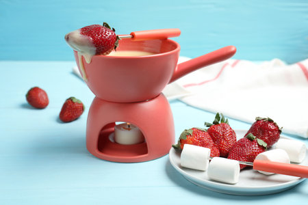 Chocolate fondue with strawberries and marshmallow on wooden tableの写真素材