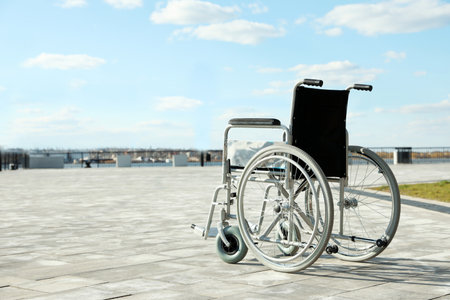 Empty wheelchair outdoors on sunny day. Space for textの写真素材
