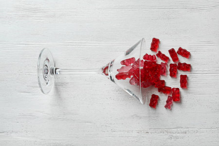 Martini glass with delicious jelly bears on wooden background, top viewの写真素材