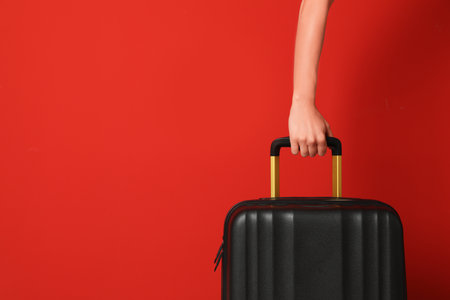 Woman with stylish suitcase against color background, closeup. Space for textの写真素材