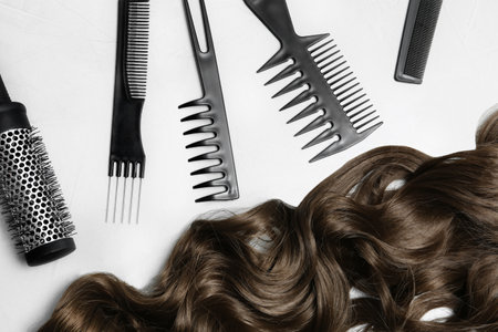Flat lay composition with brown hair and hairdresser's tools on light backgroundの写真素材