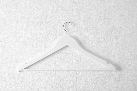 Empty clothes hanger on light wall. Wardrobe accessoryの写真素材