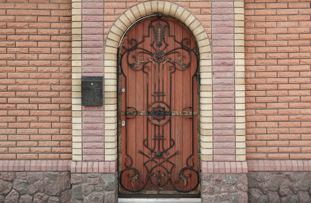 Building entrance with ornate arched wooden doorの写真素材
