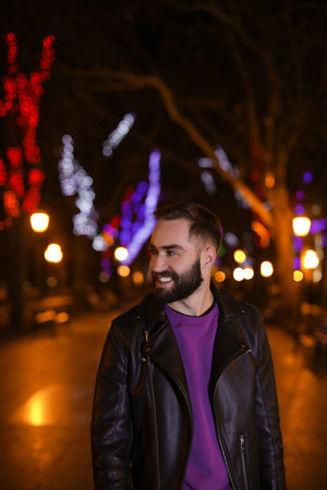 Handsome young man spending time in city at night