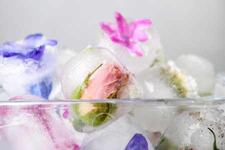 Glass bowl with floral ice cubes on light background, closeupの写真素材