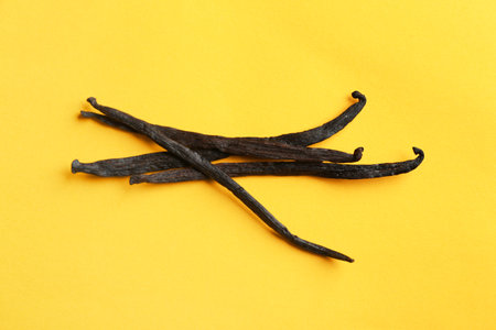 Bunch of aromatic vanilla sticks on yellow backgroundの写真素材