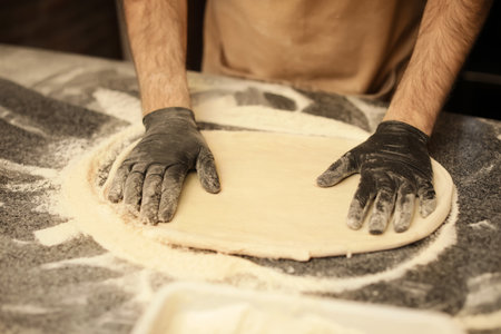Man making pizza at table, closeup viewの写真素材