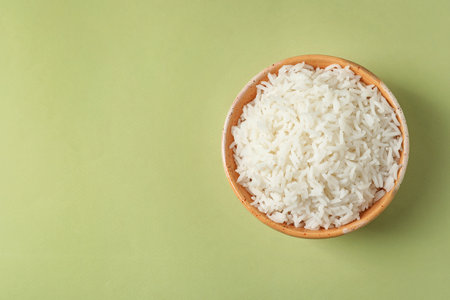 Bowl of tasty cooked rice on color background, top view. Space for textの写真素材