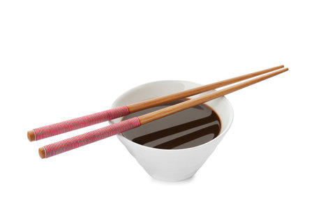 Bowl of soy sauce and chopsticks on white backgroundの写真素材