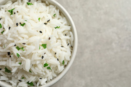 Bowl of tasty cooked rice on gray background, top view. Space for textの写真素材